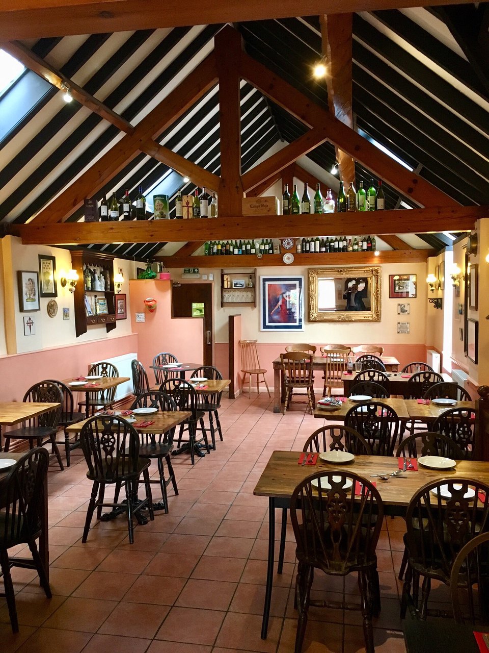 Casa Naranjo dining room with timber roof beams, terracotta floor and set tables